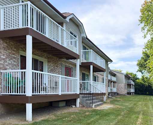 Apartment complex with white railings and brown roofs.