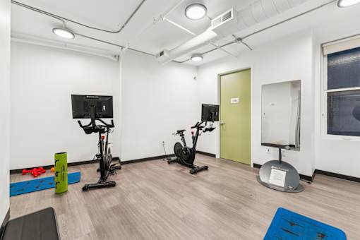 A gym with exercise equipment and a TV.