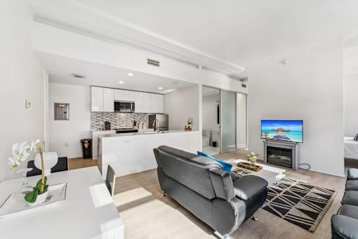 A modern living room with a grey sofa and a television.