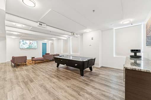 A room with a pool table and a bench.