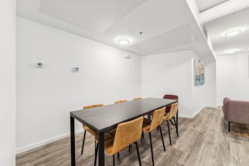 A conference room with a long table and chairs.