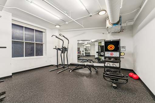 A gym with a treadmill, exercise bike, and other equipment.