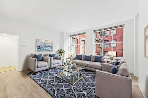 A living room with a grey sofa and a glass coffee table.