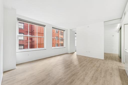 A room with a white wall and a window with a red frame.