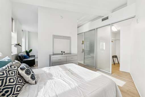 A bedroom with a large bed and a glass wardrobe.