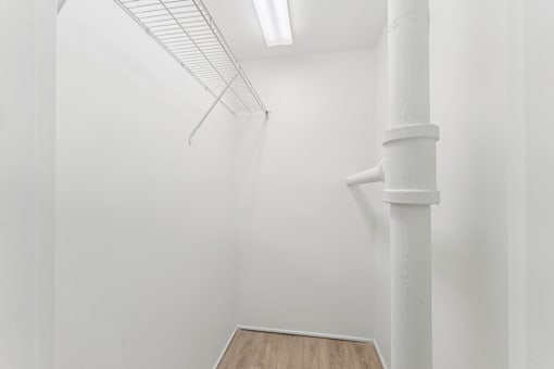 A white room with a white column and a white shelf.