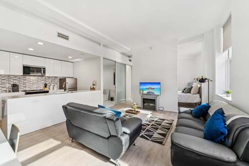 A modern living room with a grey sofa and a television.