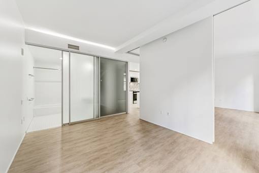 A room with a white wall and a wooden floor.
