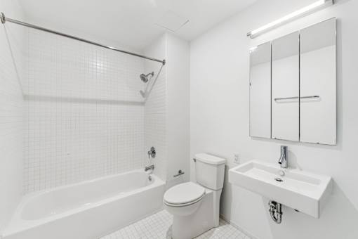 A white bathroom with a toilet, sink, and bathtub.