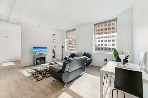 A living room with a grey couch and a television.