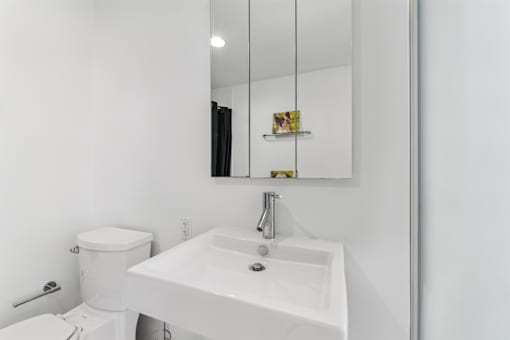 A white sink in a bathroom with a mirror above it.