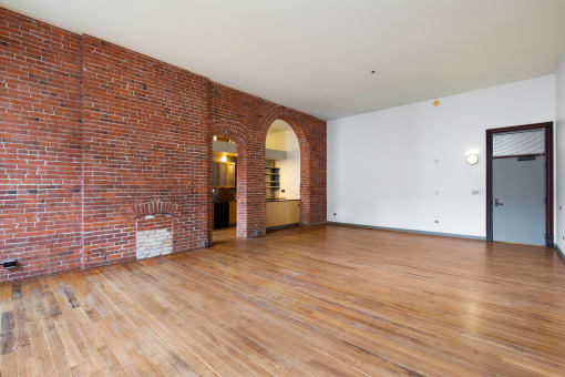 a living room with a brick wall and wooden floors
