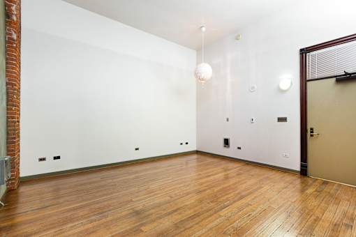 a living room with a hard wood floor and white walls