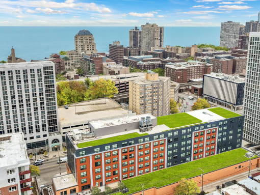 an aerial view of a city with a green roof on a building