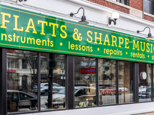 a storefront with a green sign that reads floats  shape music instruments lessons and repairs
