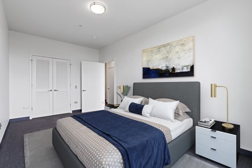 A bedroom with a bed, nightstand, and a painting on the wall.