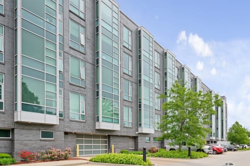 A modern building with grey and white exterior and large windows.