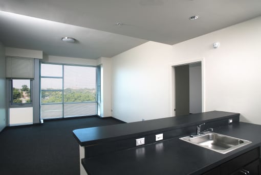 Park Boulevard Living Room Shot with partial view of kitchen counter, and view of large floor to ceiling windows