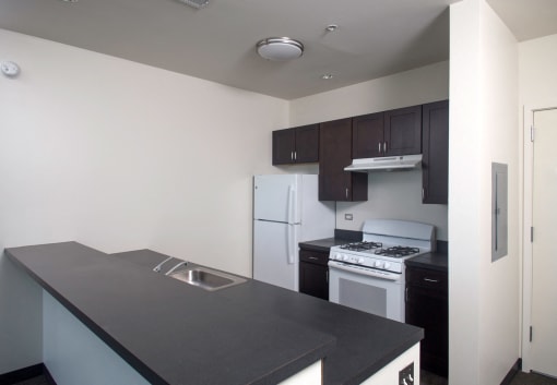 Park Boulevard IIB image of Kitchen with white appliances including Fridge and stove, partial view of sink, and entry way