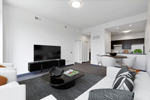 A modern living room with a black coffee table and a flat screen TV.
