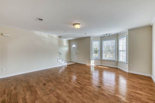 A room with wooden flooring and white walls.
