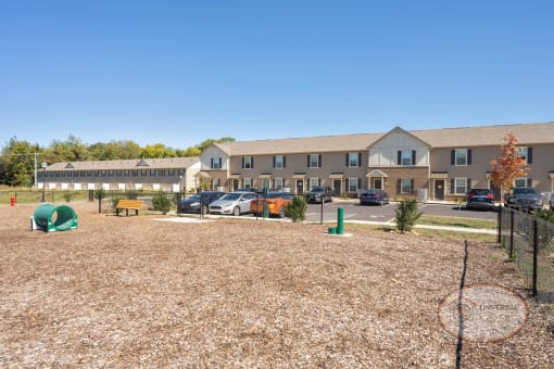A dog park with seating, water station for pets, pet waste pick-up station, and obstacles for your dog to play on.