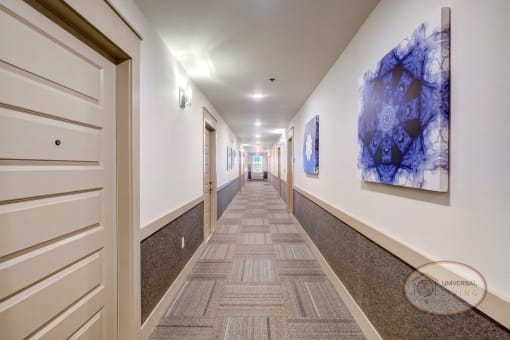 A white, carpeted hallway leading to the apartment units.