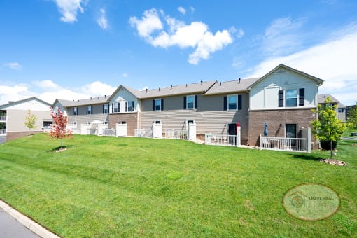 an apartment building with a lawn in front of it