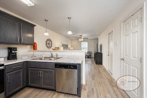 A kitchen with dark wood cabinets and a white countertop.