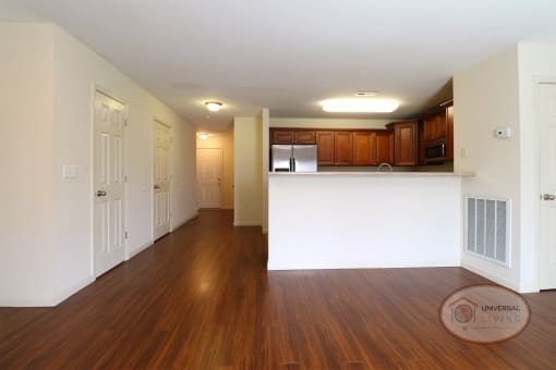 Apartment interior living room and kitchen with white walls and dark floors,