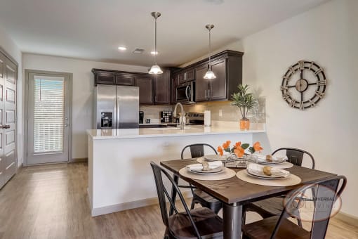 A kitchen with stainless steel appliances, white countertops, and dark cabinets.