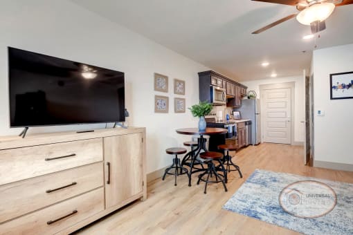 A studio apartment with flat screen TV, dining area, and kitchen.