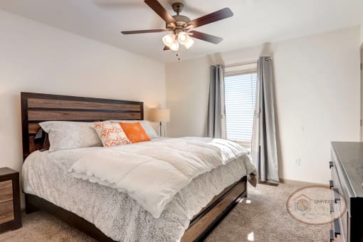 A bedroom with a bed and a ceiling fan