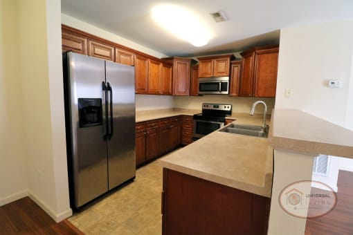 A kitchen with stainless steel appliances and wooden cabinets.