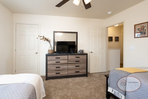 a bedroom with a bed and a dresser with a tv
