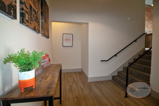 The Henry on main lobby with stairs, a table with a plan in a smiling planter, and a hallway.
