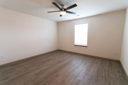 Primary first floor bedroom with a ceiling fan and a window.