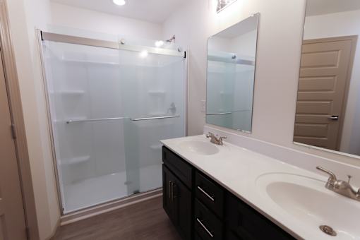 Double bathroom with a white sink and a glass walk-in shower.