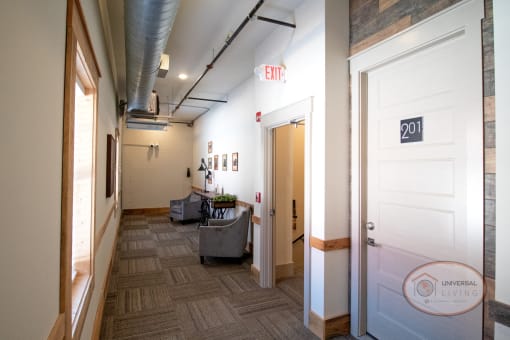 A sitting area on the second floor with lounge chairs and artwork on the walls.