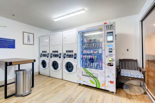 A laundry center with washers, dryers, and a vending machine.