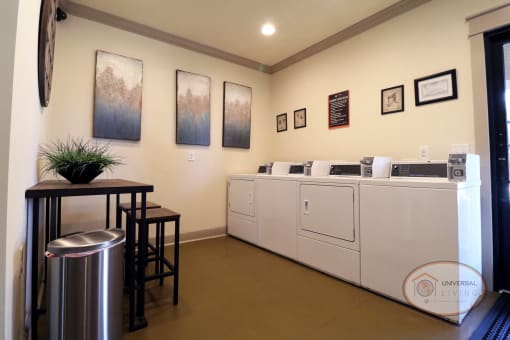 A laundry center with washers, dryers, and seating.