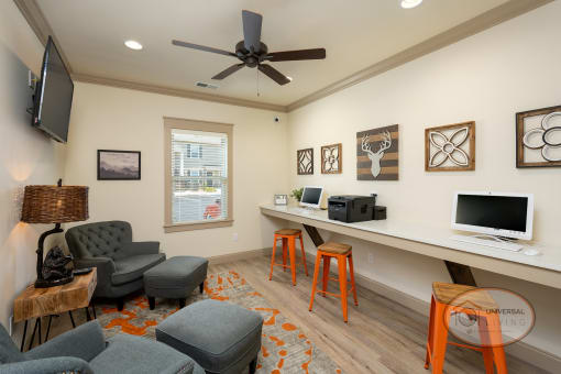 a living room with a desk with a computer and a television