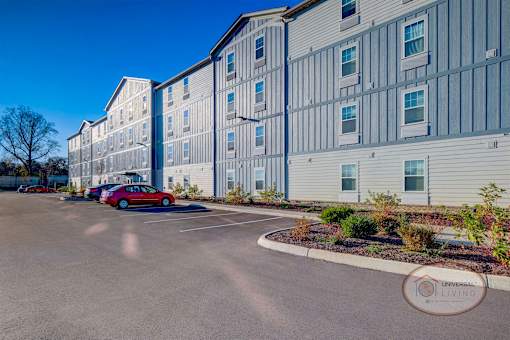 A view of the exterior of the blue and grey apartment building.