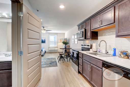 A view into a studio apartment with the kitchen on the right and a bathroom on the left.
