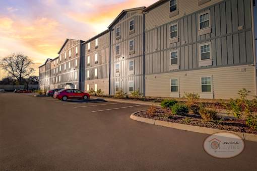 A view of the exterior of the apartment complex at sunset.