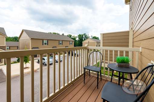 A balcony with a table and chairs overlooking a street.