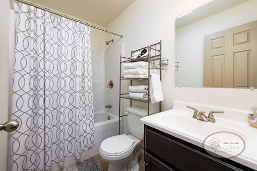 A bathroom with a toilet, sink, and shower.