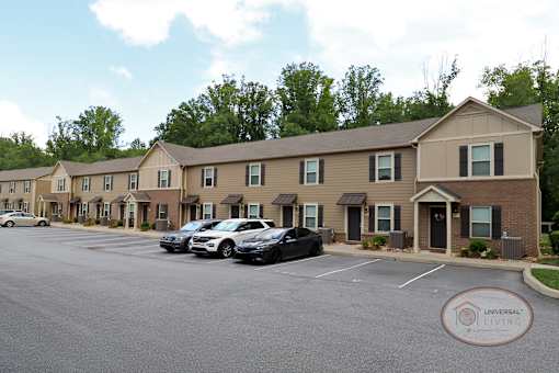 A row of two and three bedroom apartments with orange accent doors.