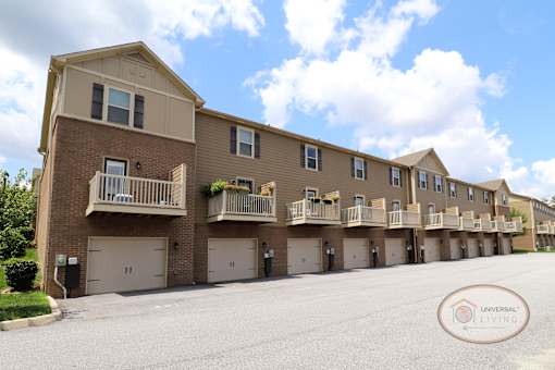 A row of 2 and 3 bedroom apartment homes with balconies and garage doors.