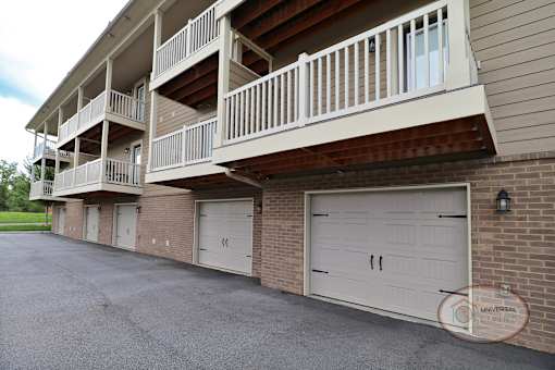 An up close image of an apartment building with a balcony and garage.